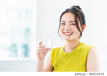 ミネラルウォーターを飲む若い女性 80610243