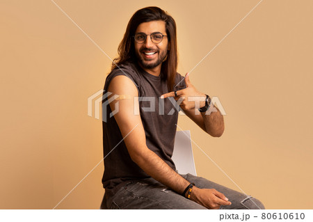Handsome indian man got vaccinated, pointing at shoulder with plaster Handsome indian man got vaccinated, pointing at shoulder with plaster 80610610