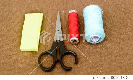 Group of sewing tools and items for knitting and weaving placed on a brown colour woven paper board. DIY Art and craft background concept. Group of sewing tools and items for knitting and weaving placed on a brown colour woven paper board. DIY Art and craft background concept. 80611330