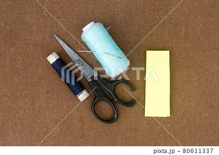 Group of sewing tools and items for knitting and weaving placed on a brown colour woven paper board. DIY Art and craft background concept. 80611337