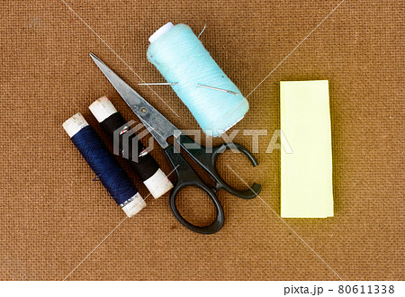 Group of sewing tools and items for knitting and weaving placed on a brown colour woven paper board. DIY Art and craft background concept. 80611338