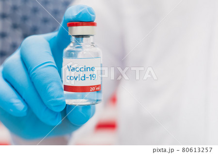 Doctor holding vaccine bottle with USA flag background. Doctor holding vaccine bottle with USA flag background. 80613257