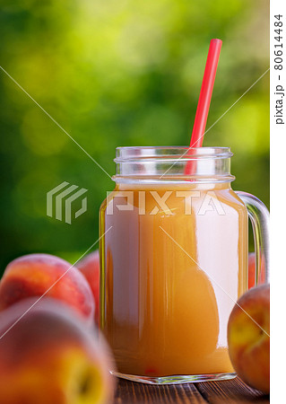 peach juice in glass mason jar with ripe fruits peach juice in glass mason jar with ripe fruits 80614484