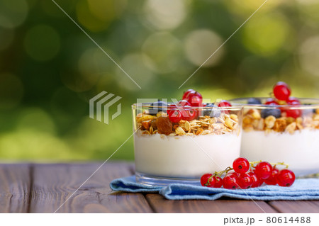 granola with greek yogurt and berries in two glasses 80614488