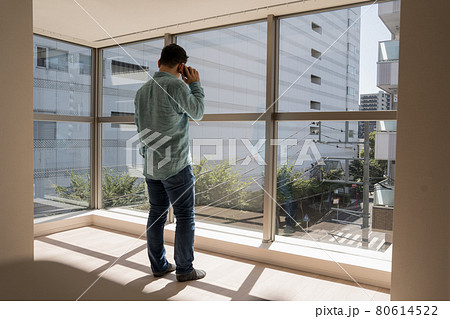 とても日当たりのよい新築マンションのリビングでスマホを使って電話する中年男 とても日当たりのよい新築マンションのリビングでスマホを使って電話する中年男 80614522