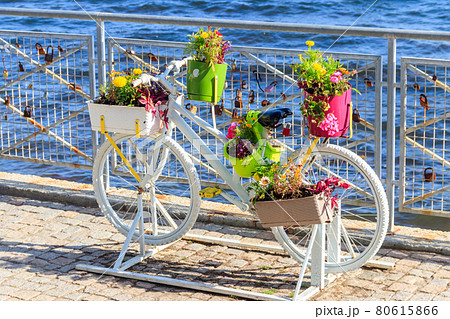 Decorative bicycle shape stand for plants and flowers on the embankment by a sea Decorative bicycle shape stand for plants and flowers on the embankment by a sea 80615866
