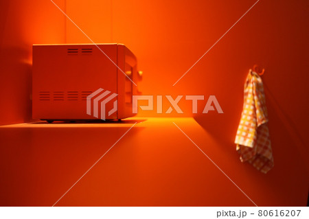 orange microwave at orange kitchen with white towel. heating energy inside microwave oven. orange microwave at orange kitchen with white towel. heating energy inside microwave oven. 80616207