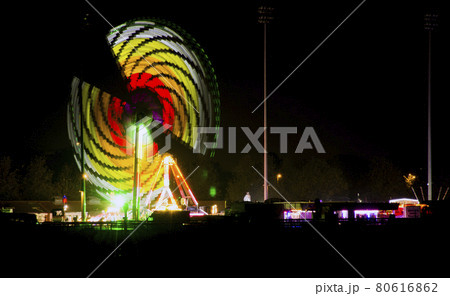 Artificial rainbow - Colorful carousel by night in Kempton Park, London, UK Artificial rainbow - Colorful carousel by night in Kempton Park, London, UK 80616862