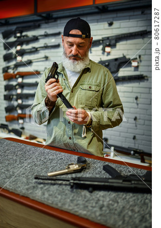 Man reload handgun at the counter in gun store Man reload handgun at the counter in gun store 80617287