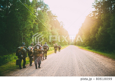 Unidentified re-enactors dressed as German soldiers during march through forest Unidentified re-enactors dressed as German soldiers during march through forest 80618099