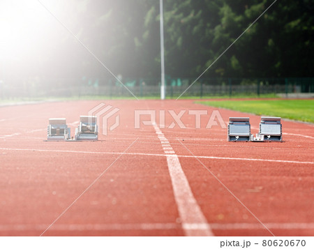 Starting blocks on red running tracks, light reflection an lens flare 80620670