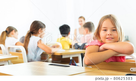 Schoolgirl sitting in classroom 80625383
