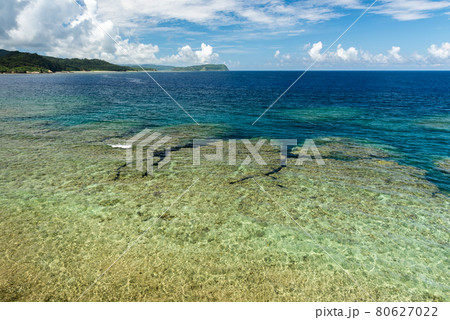 Stunning top view of a jagged coral reef at low tide, crystalline sea, deep blue ocean, blue sky. Iriomote Island. Stunning top view of a jagged coral reef at low tide, crystalline sea, deep blue ocean, blue sky. Iriomote Island. 80627022