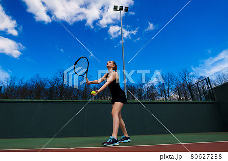 Sexy girl tennis player holding tennis racket on the court. Young woman is playing tennis. 80627238