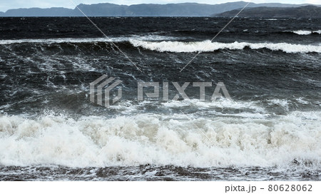White foam waves run on the rocky shore of the white sea. Dramatic sky, epic seascape. A storm at sea. Nordic, Barents Sea, ocean 80628062
