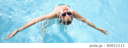 Young woman in sunglasses swimming in pool top view Young woman in sunglasses swimming in pool top view 80631215