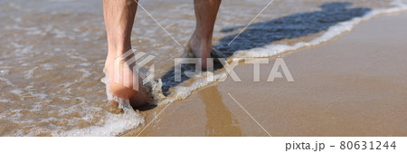 Man feet walking along sandy beach closeup Man feet walking along sandy beach closeup 80631244