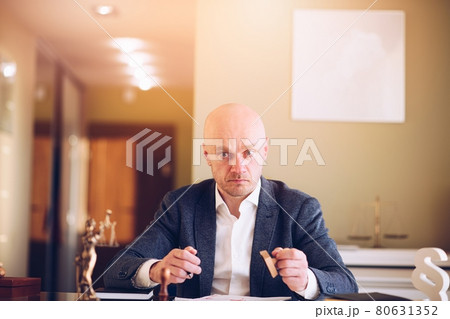 Lawyer or attorney working in the office. He prepares and signs documents for clients. Lawyer or attorney working in the office. He prepares and signs documents for clients. 80631352