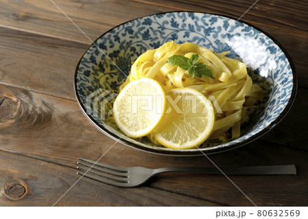 輪切りにカットされたレモンやスペアミントが乗っているレモンクリームパスタとフォーク 80632569