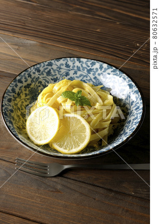 輪切りにカットされたレモンやスペアミントが乗っているレモンクリームパスタとフォーク 80632571