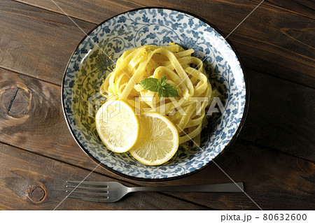 輪切りにカットされたレモンやスペアミントが乗っているレモンクリームパスタとフォークを俯瞰で撮影 輪切りにカットされたレモンやスペアミントが乗っているレモンクリームパスタとフォークを俯瞰で撮影 80632600