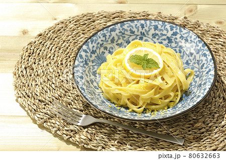 輪切りにカットされたレモンやスペアミントが乗っているレモンクリームパスタとフォーク 80632663