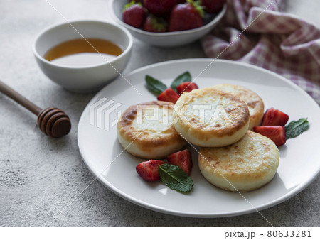 Cottage cheese pancakes, ricotta fritters on ceramic plate with fresh strawberry. Cottage cheese pancakes, ricotta fritters on ceramic plate with fresh strawberry. 80633281