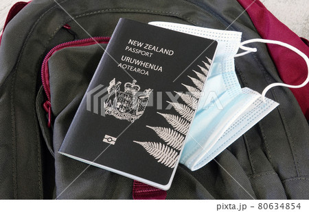Travel concept during pandemic, New Zealand passport and face mask on a backpack.. 80634854