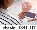 Young Asian woman with portable fan at workplace. Summer season. 80634855