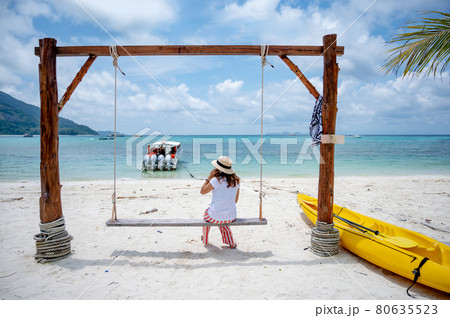 Asian woman tourist sitting on wooden swing on the beach 80635523