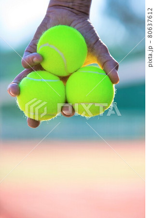 Photo of senior man holding tennis balls on court 80637612
