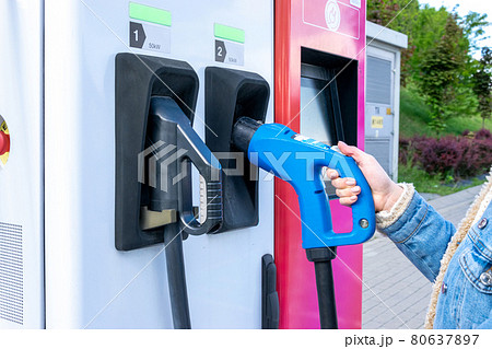 Electric car charging station. Power cable pump plug in recharge fuel technology with cable to power battery. Eco green energy hybrid vehicle on future charger station. EV fuel Plug in hybrid car. 80637897