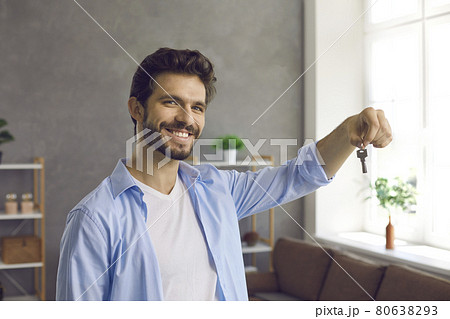 Portrait of happy smiling young man showing us keys to his new house or apartment 80638293