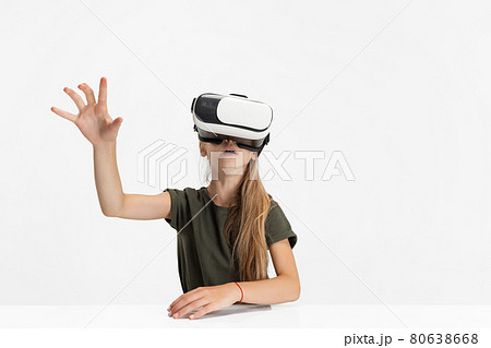 One smart teen school caucasian girl in VR glasses isolated over white studio background. One smart teen school caucasian girl in VR glasses isolated over white studio background. 80638668