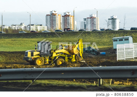 Broken two bulldozers at a construction site on the background of cars and urban buildings Broken two bulldozers at a construction site on the background of cars and urban buildings 80638850