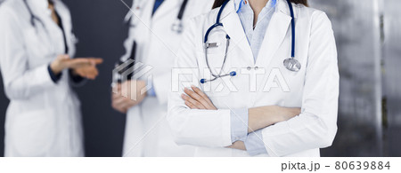 Unknown young woman doctor is standing with arms crossed in clinic. Medicine concept during Coronavirus pandemic 80639884