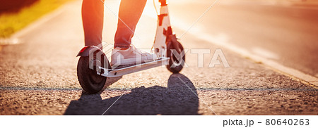 Woman riding on scooter on asphalt in summer 80640263