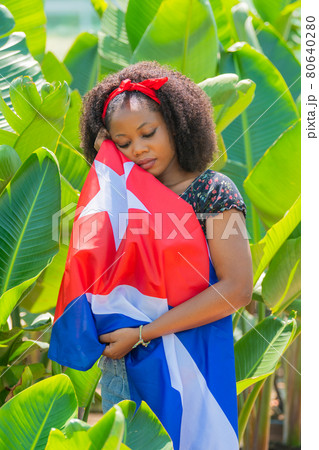 Vertical photo of an Afro woman caressing a Cuban flag Vertical photo of an Afro woman caressing a Cuban flag 80640280