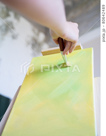 Creating a colorful artwork. Professional artist draws on an easel Creating a colorful artwork. Professional artist draws on an easel 80642489