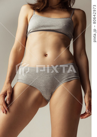 Beautiful body of young caucasian woman isolated on gray studio background. Natural beauty concept. Bottom view Beautiful body of young caucasian woman isolated on gray studio background. Natural beauty concept. Bottom view 80642973