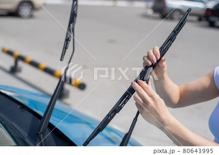 Faceless woman changing car windshield wipers. Faceless woman changing car windshield wipers. 80643995