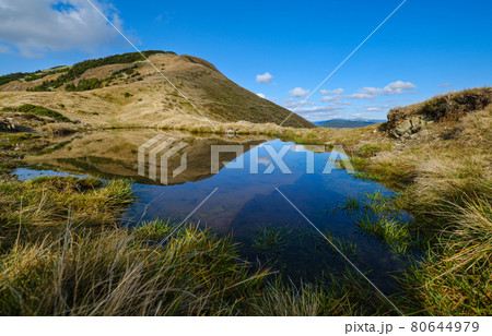 Small picturesque lake with clouds reflections at the  Strymba Mount. Beautiful autumn day in Carpathian Mountains near Kolochava village, Transcarpathia, Ukraine. 80644979