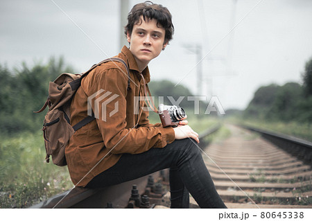Photographer in brown jacket with backpack 80645338