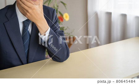 在宅ワークで考え事をするビジネスマン。頬杖をつく男性。 在宅ワークで考え事をするビジネスマン。頬杖をつく男性。 80645484