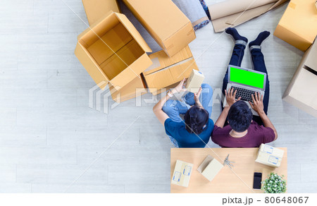 Top view of young asian couple working online shopping on laptop computer with cardboard parcel boxs of product for deliver at home. Start up online business concept. green screen computer Top view of young asian couple working online shopping on laptop computer with cardboard parcel boxs of product for deliver at home. Start up online business concept. green screen computer 80648067
