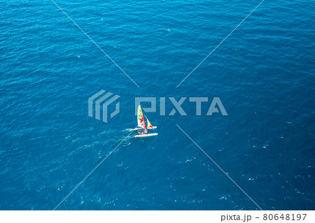 Aerial view of portable sailboat windsurfing catamaran in blue water of Adriatic Sea Aerial view of portable sailboat windsurfing catamaran in blue water of Adriatic Sea 80648197