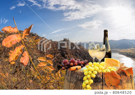 Bottle of wine on barrel against Duernstein castle close to Danube river during autumn in Wachau, Austria 80648520