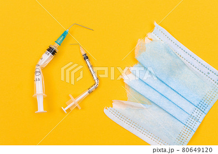 Broken Medical Syringe and Torn Medical Face Mask 80649120