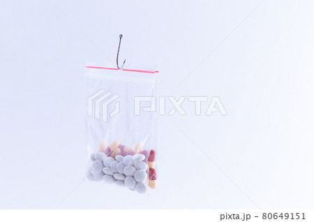 Colored Pills or Tablets Hanging in Small Ziplock Bag on a Fishing Hook 80649151