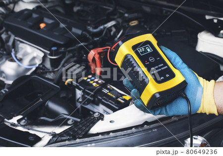 Technician recharge car battery with automatic battery charger Technician recharge car battery with automatic battery charger 80649236